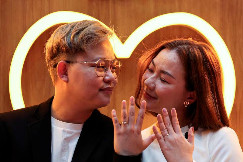 An LBGTQ+ couple, Pawan Iamwet, 35, and Kamonchanok Chumruan, 38, pose for a picture as they wait to receive official marriage certificates - REUTERSpix