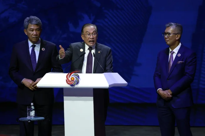 AKL353_28102025_ASEAN_SUMMIT Prime Minister Datuk Seri Anwar Ibrahim speaks during the press conference for the 47th ASEAN Summit and Related Summits at the Kuala Lumpur Convention Centre today. Also present are Foreign Minister Datuk Seri Mohamad Hasan (left) and Investment, Trade and Industry Minister Tengku Datuk Seri Zafrul Abdul Aziz.