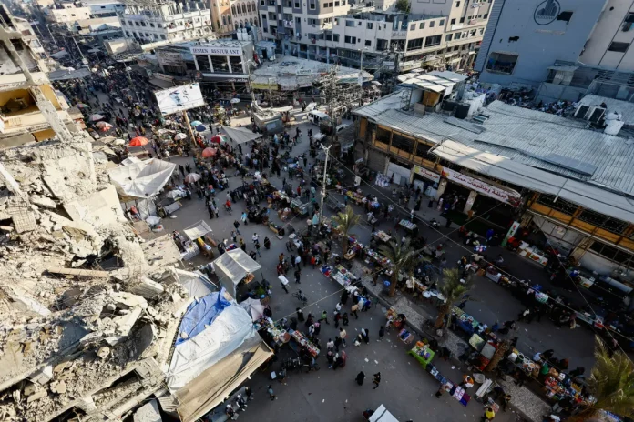 People gather and shop at a local market, in Nuseirat, central Gaza Strip, October 28, 2025. REUTERS