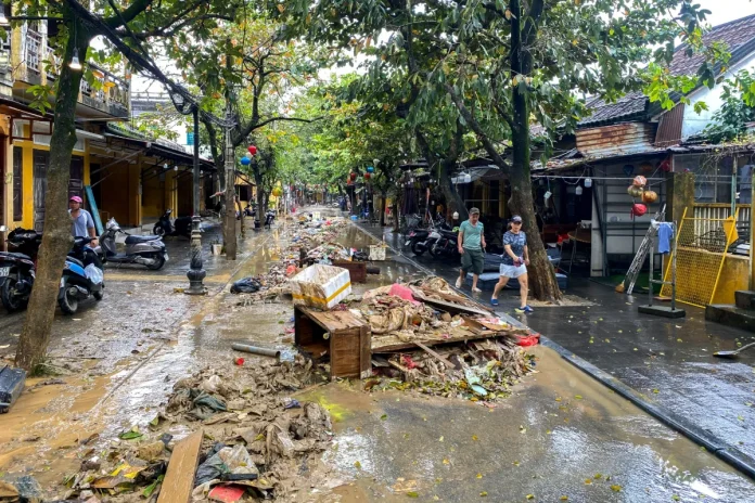 People walk past debris following floods in central Vietnam that have killed several people, in Hoi An, Vietnam, November 1, 2025. REUTERS