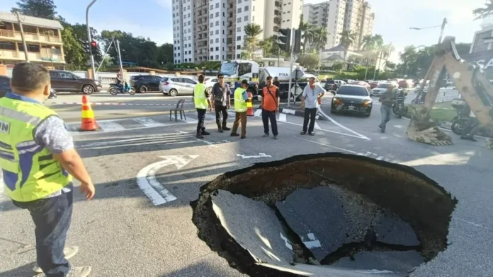 A team from the Penang JKR and Bayan Lepas assemblyman Azrul Mahathir Aziz (in blue) at the site of the road cave-in. Pic courtesy of Azrul Mahathir Aziz Facebook page