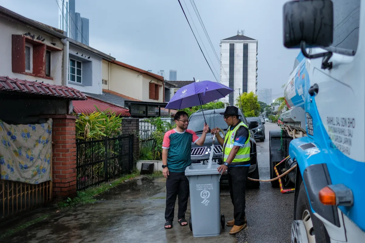jb13-02112025-tadah-air Resident, Ahmad Rizal Akiah (left), sees Ranhill SAJ workers filling water for his house in Taman Pelangi after receiving water supply assistance from a Ranhill SAJ tanker lorry following unscheduled water supply disruptions due to pollution of the Johor River, as of 10am this morning. -Bernama