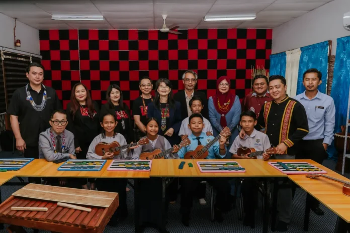 Mohamad Sufri Salim, Chief Assistant Director, Special Education Sector, Sabah State Education Department [bottom row, first from left], Josephine Tan, Campus Director, Taylor's College [top row, middle], Yang Berbahagia Datuk Ceasar Mandela Malakun, Senior Private Secretary to Yang Amat Berhormat Chief Minister of Sabah [top row, first from left], Muhammad Hamka Eallie, Headmaster of Sekolah Kebangsaan Pendidikan Khas Kota Kinabalu (SKPK KK) [top row, fifth from right], Hairiah Daud, Assistant District Education Officer, Tuaran, Special Education Unit, Learning Sector [top row, fourth from right] and Stefanus Lucas, RISE Educator Award 2025 recipient [top row, second from right], accompanied by students with learning disabilities in the upgraded Bilik Muzik Inklusif.