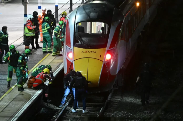 Police officers and members of the Emergency services search the track beneath an LNER Azuma train at Huntingdon Station in Huntingdon, eastern England, on November 1, 2025, following a stabbing on a train. UK police said they had arrested two suspects Saturday as 