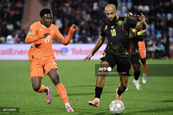 Cameroon's midfielder #10 Bryan Mbeumo (R) fights for the ball with Ivory Coast's midfielder #19 Christ Inao Oulai (L) during the Africa Cup of Nations (CAN) Group F football match between Ivory Coast and Cameroon at Marrakesh Stadium in Marrakesh on December 28, 2025.