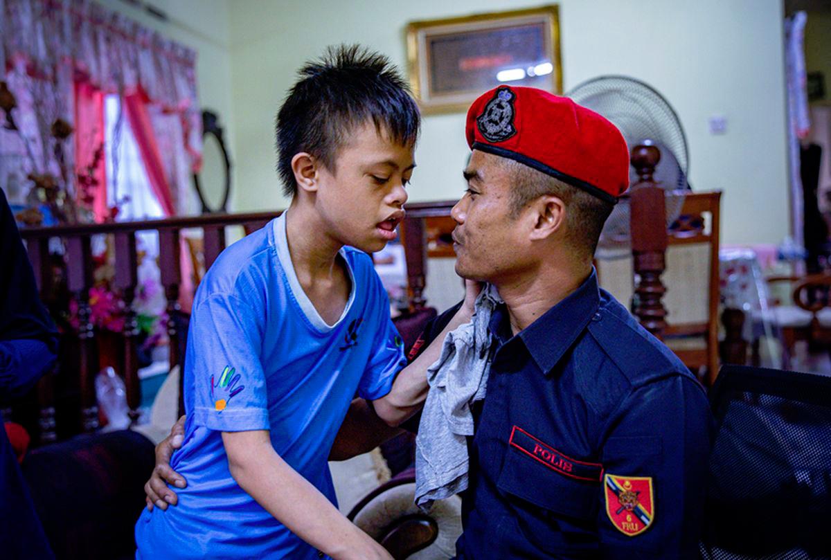 Heartbreaking moment as friend comforts late FRU officer’s disabled son