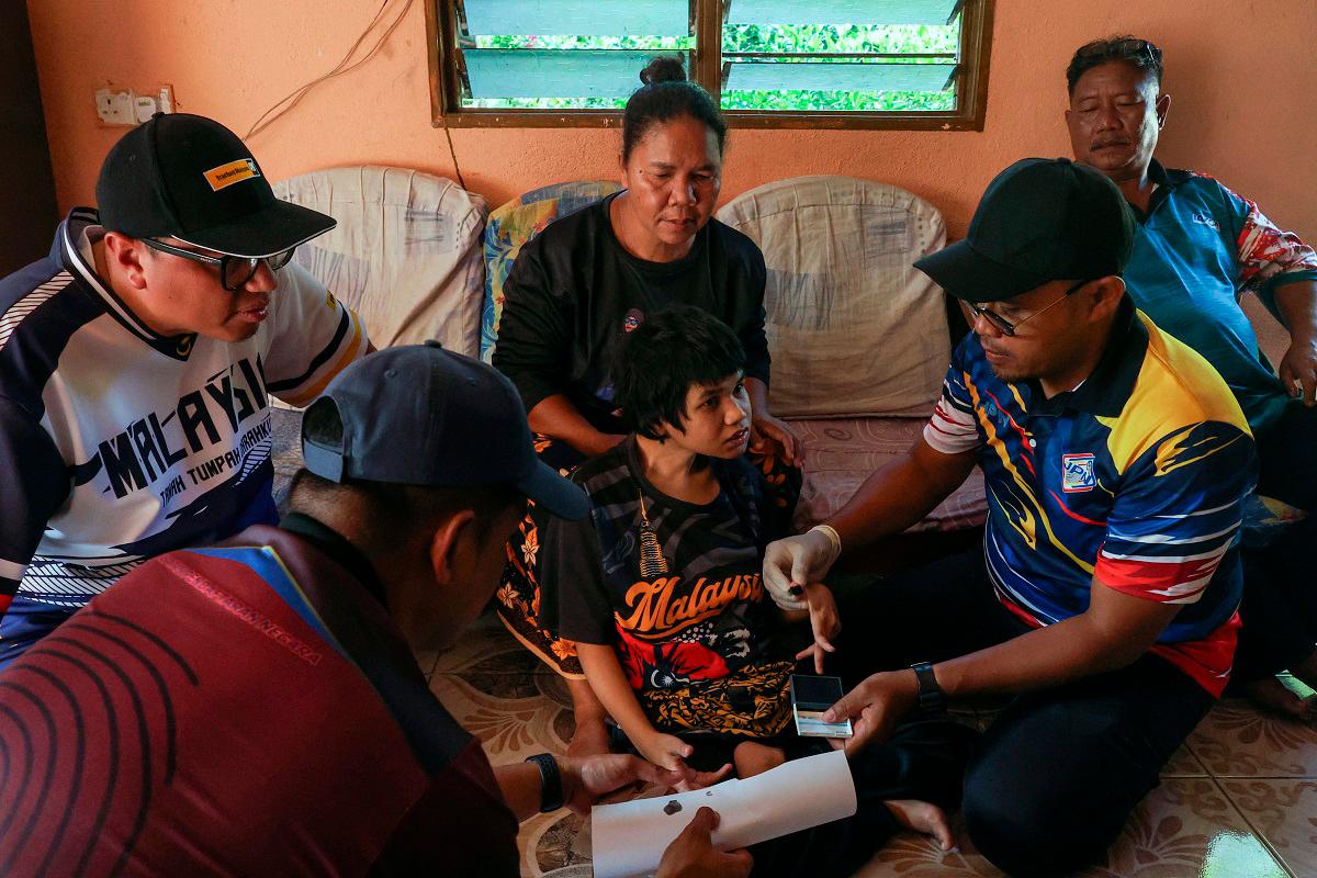 JPN helps bedridden Orang Asli woman renew MyKad in home visit JPN helps bedridden Orang Asli woman renew MyKad in home visit