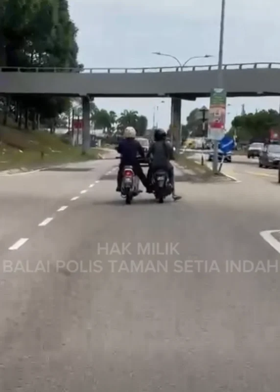 Kind-hearted PDRM officers lend a hand to motorcyclists who ran out of petrol