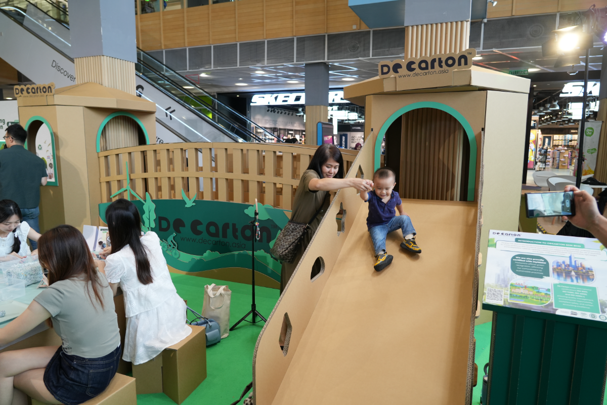 Greener living: green products, lower waste A child plays on an indoor playground built entirely from cardboard by de carton, demonstrating how sturdy, recyclable materials can be.