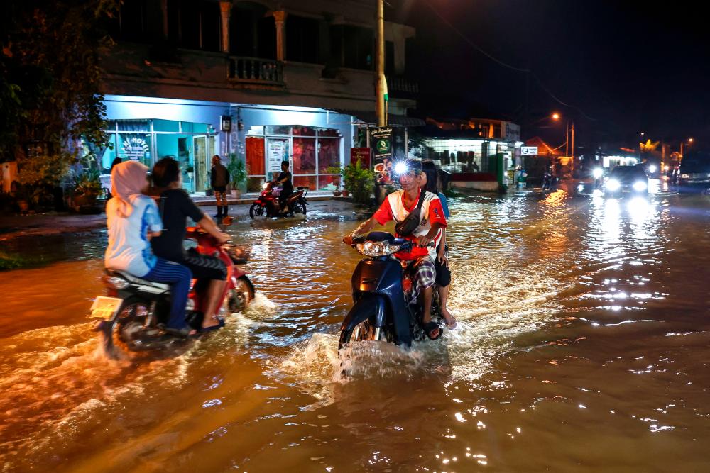 Business goes on in Rantau Panjang as usual despite rising flood waters Business goes on in Rantau Panjang as usual despite rising flood waters