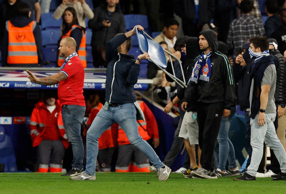 Espanyol fan invades the pitch and throws a chair after FC Barcelona players celebrate winning LaLiga