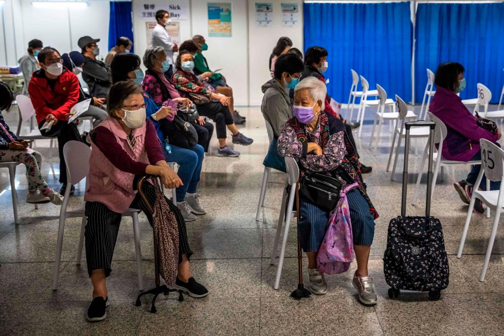Hong Kong leader urges vaccinations as Covid infections swamp city