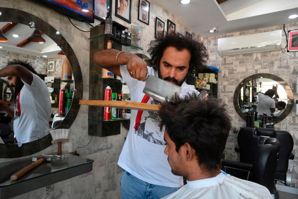 With cleavers and blowtorches, Pakistan barber offers hair-raising cuts