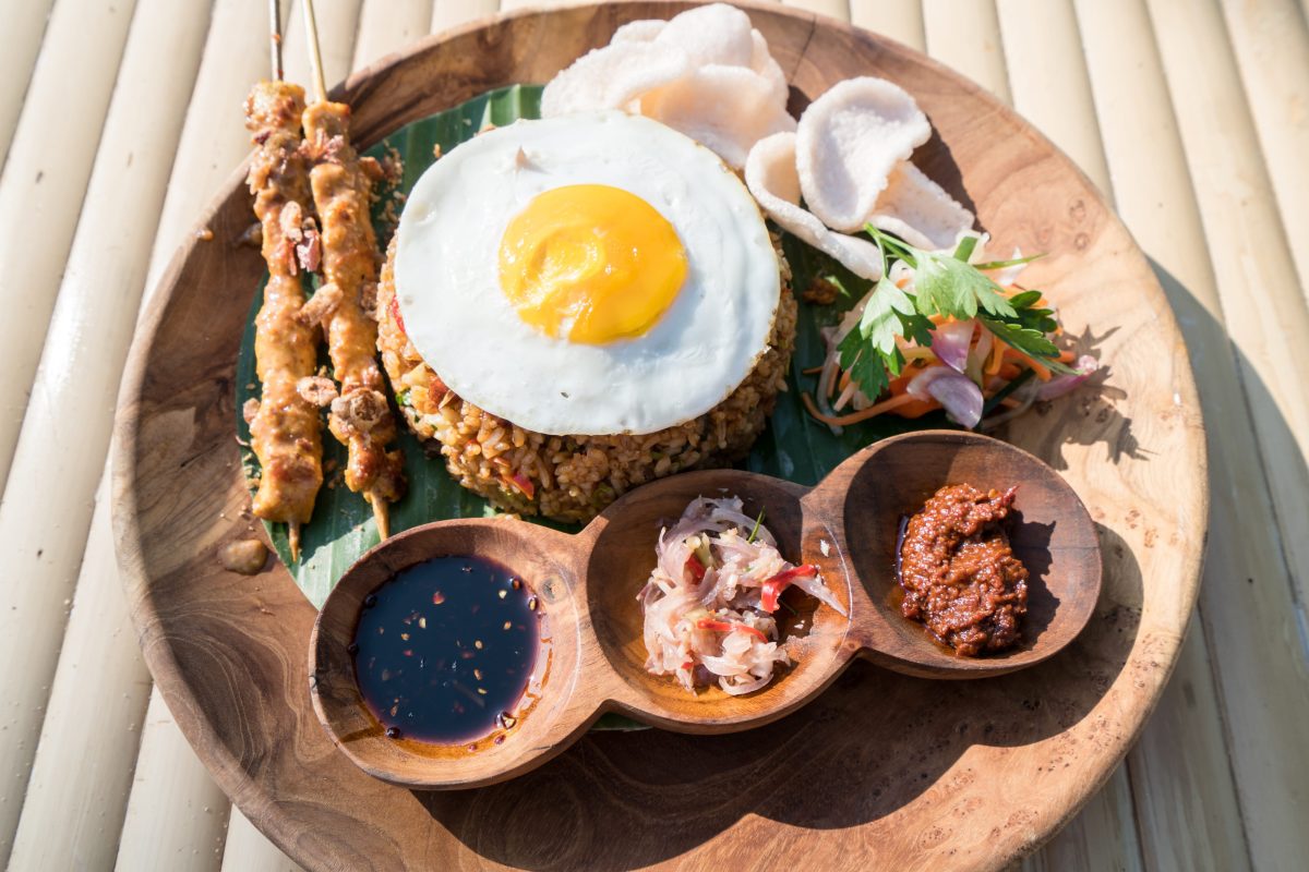 Nasi goreng typically includes a fried egg on top as a common finish, adding richness to the dish.