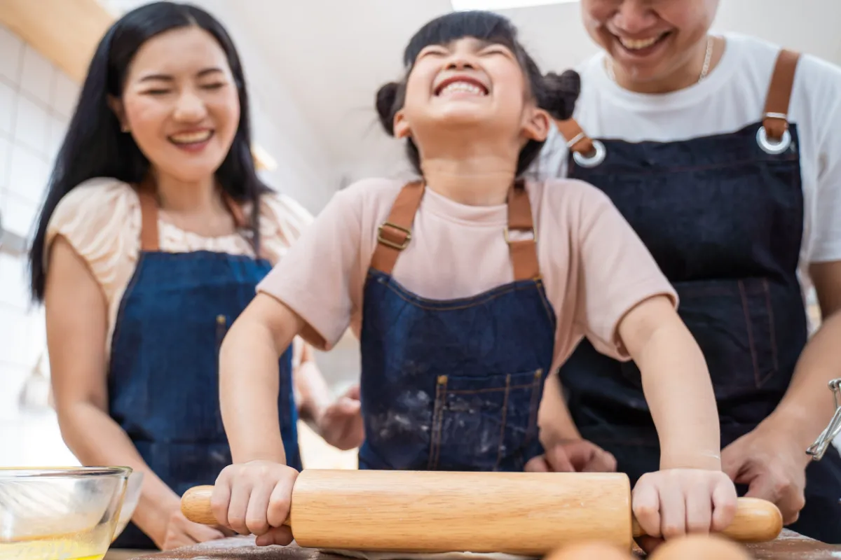 Children involved in cooking activities are often introduced to food preparation through structured, hands-on tasks rather than observation alone.